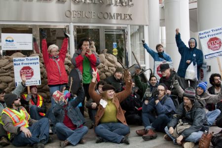 Climate Justice rally in Vancouver sandbags office of BC premier and cabinet. Photo: Erin Empey