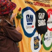 Protesters on the drive hold up banners showing their resistance to the tar sands