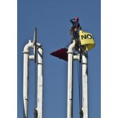 Greenpeace members atop a Kinder Morgan dockside oil pump