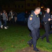 Campers shouting "Homes Not Jails" (and media)  follow police around camp