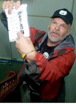 As the aid ship is under attack, Kevin Neish holds up a "hit list" found in an Israeli commando's backpack. Photo: Iara Lee