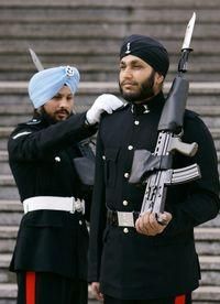 Queen Elizabeth II has switched bearskin hats for turbans outside Buckingham Palace, where Sikh soldiers have begun guarding the monarch and her treasures.